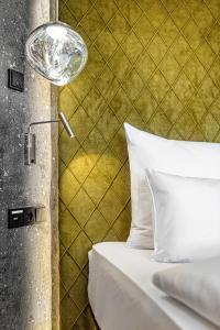 un letto con lampada accanto a un muro di Alpines Lifestyle Hotel Tannenhof a Sankt Johann im Pongau