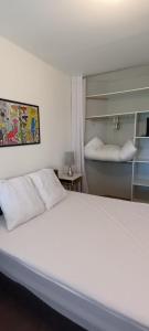 - une chambre avec un lit blanc et une étagère dans l'établissement Maison avec piscine privée aux portes des Cévennes, à Saint-Christol-lès-Alès