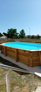 une grande piscine avec une terrasse en bois dans l'établissement Maison avec piscine privée aux portes des Cévennes, à Saint-Christol-lès-Alès