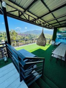 a patio with a bench and a table on a deck at Elevated Serenity Lodge in Khao Kho in Khao Kho