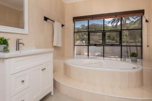 baño blanco con bañera y ventana en The Beach Palace Ramsgate, en Margate