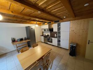 - une cuisine avec des appareils blancs et une table en bois dans l'établissement Pension Balm, à Meiringen