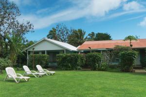 two white chairs sitting in the yard of a house at Hostal y Cabañas Aorangi in Hanga Roa