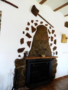 sala de estar con chimenea y pared de piedra en Casa Triana en Cuevas del Campo
