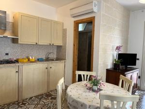 una cucina con tavolo e sedie e una cucina con bancone di Casette Masseria La Camardia a Sava