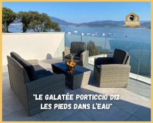 eine Terrasse mit Stühlen und einem Tisch mit Blick auf das Wasser in der Unterkunft Le Galatée Porticcio in Porticcio
