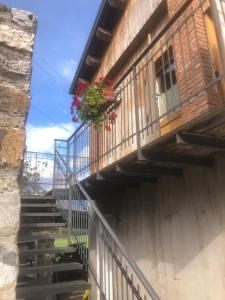 Una escalera con un balcón con flores. en Il mondo roverso, en Feltre