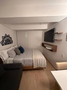 a bedroom with a bed and a flat screen tv at Apartaloft La Candelaria Downtown Bogota in Bogotá