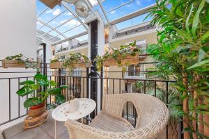 an indoor balcony with wicker chairs and potted plants at Tranquil 2 bedroom Apartment Close to St. Paul's Cathedral in London