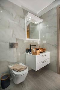 a white bathroom with a toilet and a mirror at Villa Stone Diamond in Sívas