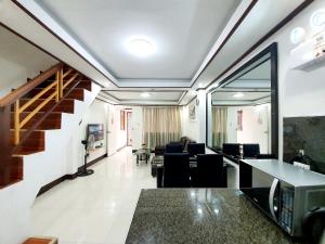 a living room with a staircase and a room with chairs at Calapan Transient House Acacia L35 in Calapan