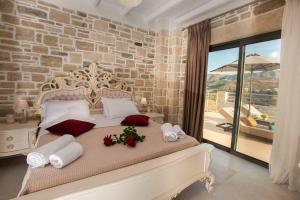 a bedroom with a large bed with a stone wall at Villa Stone Diamond in Sívas +33 photos