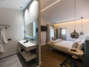 a bedroom with a bed and a sink and a mirror at INFINITVM in Sigüenza