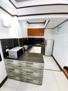 a kitchen with a counter top with a microwave at Calapan Transient House Acacia L35 in Calapan