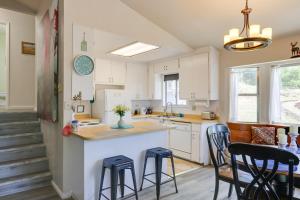 a kitchen with white cabinets and a island with stools at Tuolumne Vacation Rental about 45 Mi to Yosemite in Tuolumne