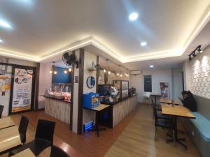 a fast food restaurant with a woman sitting at a table at Behomy Corner Eight Lippo Karawaci in Tangerang