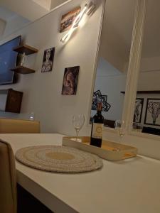 a bottle of wine and two glasses on a counter at Apartaloft La Candelaria Downtown Bogota in Bogotá