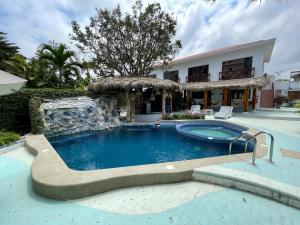 a large swimming pool in front of a house at Hosteria Punta Blanca in Punta Blanca