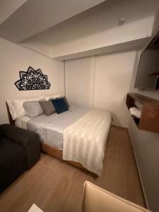a small bedroom with a bed and a couch at Apartaloft La Candelaria Downtown Bogota in Bogotá