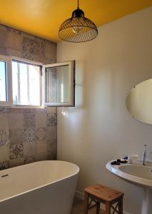 La salle de bains est pourvue d'une baignoire et d'un lavabo. dans l'établissement Chambre confortable vue sur mer, à Hyères