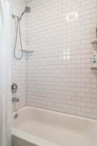 a white bathroom with a tub and a shower at Pearly Gates l 3 Bed l Sleeps 5 l w 2-Car Garage in Forest Park