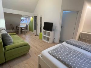 um quarto com uma cama, um sofá e uma televisão em Gaestehaus Seliger em Meersburg