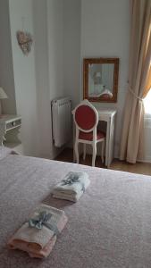 a bedroom with a bed with a red chair and a mirror at La Civetta appartamento con giardino e parcheggio in Nave