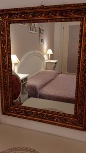 - un miroir dans une chambre d'hôtel avec un lit dans l'établissement La Civetta appartamento con giardino e parcheggio, à Nave
