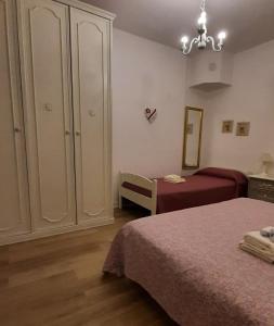 - une chambre avec deux lits, une armoire et une chaise dans l'établissement La Civetta appartamento con giardino e parcheggio, à Nave