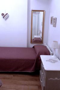 - une chambre avec un lit et un miroir mural dans l'établissement La Civetta appartamento con giardino e parcheggio, à Nave
