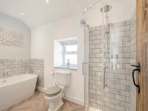 a bathroom with a tub and a toilet and a shower at Blossom Tree Cottage in Barnoldswick