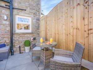 a patio with a table and chairs and a fence at Blossom Tree Cottage in Barnoldswick