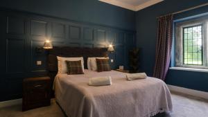 ein Schlafzimmer mit einem großen Bett mit blauen Wänden in der Unterkunft Grand Manor House Bristol-Celebrations Events Hens - Simply Check In in Bristol