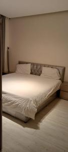 un letto con lenzuola e cuscini bianchi in una camera da letto di شالية لايت مون a Dammam