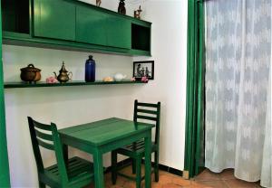 a green table and chairs in a room at Studio with sea view enclosed garden and wifi at Foulpointe in Foulpointe