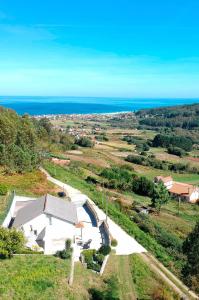 una vista aérea de una casa en una colina cerca del océano en AG Casa Anema 10 huéspedes a 2km de la playa Razo, en A Coruña