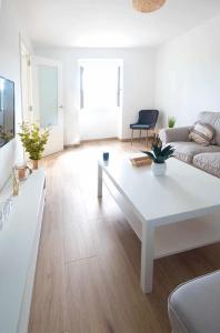 Sala de estar blanca con mesa de centro blanca en AG Casa Anema 10 huéspedes a 2km de la playa Razo en A Coruña