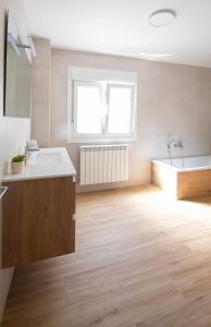 ein Badezimmer mit einer Badewanne, einem Waschbecken und einer Badewanne in der Unterkunft AG Casa Anema 10 huéspedes a 2km de la playa Razo in A Coruña