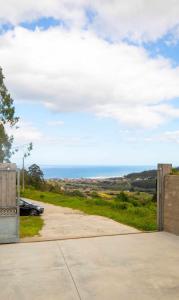 a gate to a driveway with the ocean in the background at AG Casa Anema 10 huéspedes a 2km de la playa Razo in A Coruña