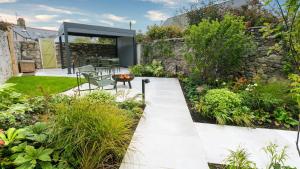 un jardín con una pared de piedra y un patio en The Papered House, en Beaumaris