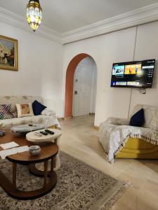 a living room with two couches and a flat screen tv at Appartement S+2 à lac 1 à côté hôtel Movempick in Tunis