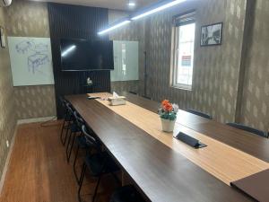 a large conference room with a long wooden table and chairs at Behomy Corner Eight Lippo Karawaci in Tangerang