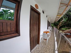 a balcony with a wooden door and a table and chairs at Hotel Randuky Tayrona in El Zaino