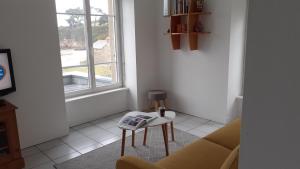 a living room with a table and a window at L'APPART DU RIS in Douarnenez