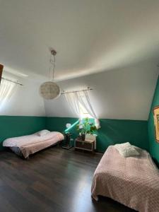 two beds in a room with green and white walls at Dom całoroczny na wynajem - Zalesie nad jeziorem Chełmżyńskim koło Torunia 