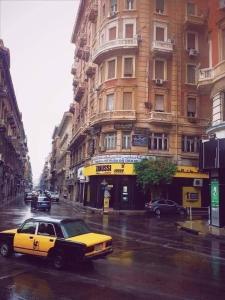 a yellow car parked on a street in front of a building at Smoha Zahran Haus (Private rooms or Private Apartment) in Alexandria