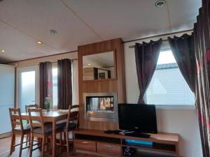 ein Esszimmer mit einem Tisch und einem TV in der Unterkunft Holiday Cottage Seaside in Knokke-Heist