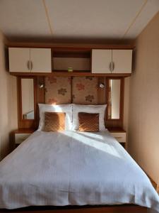 um quarto com uma grande cama branca e 2 almofadas em Holiday Cottage Seaside em Knokke-Heist