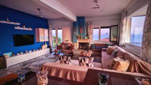 sala de estar amplia con sofá y TV en Bellevue - Panoramic Seaview Penthouse, en Pyrgadikia