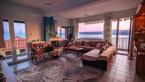 sala de estar con sofá y chimenea en Bellevue - Panoramic Seaview Penthouse, en Pyrgadikia